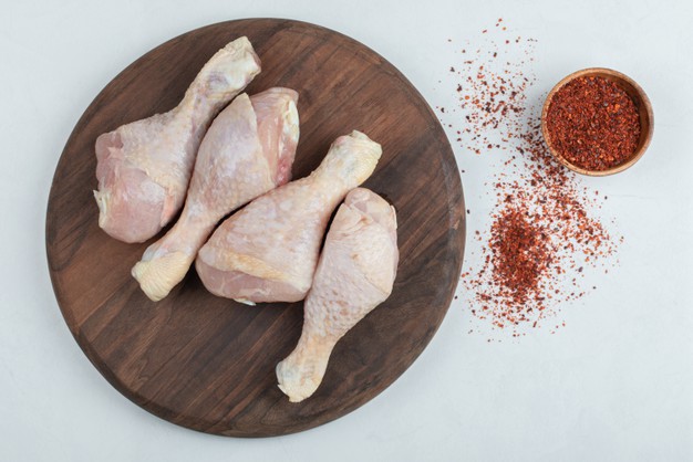raw fresh chicken legs with red hot chili peppers white background 114579 48669