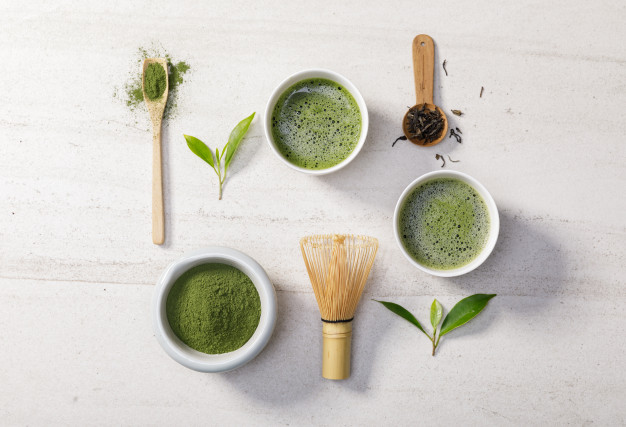 organic matcha green tea powder bowl with wire whisk green tea leaf white stone table 185216 2