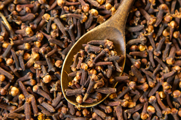 top view dried cloves with wooden spoon 140725 9082
