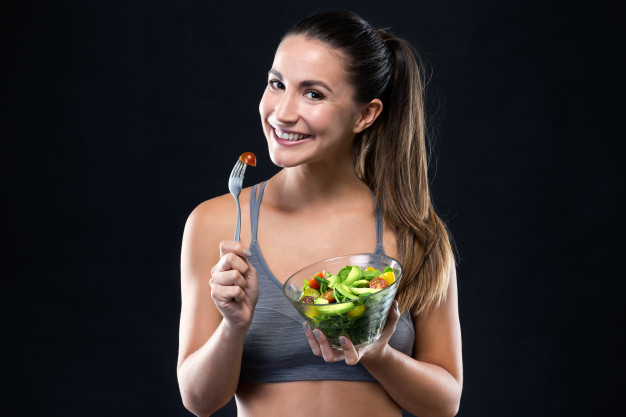 beautiful young woman eating salad black background 1301 7563