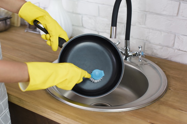 person hand with yellow glove washing pan with brush kitchen 23 2148222283