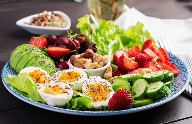 plate with paleo diet food boiled eggs avocado cucumber nuts cherry strawberries paleo breakfast 2829 3703