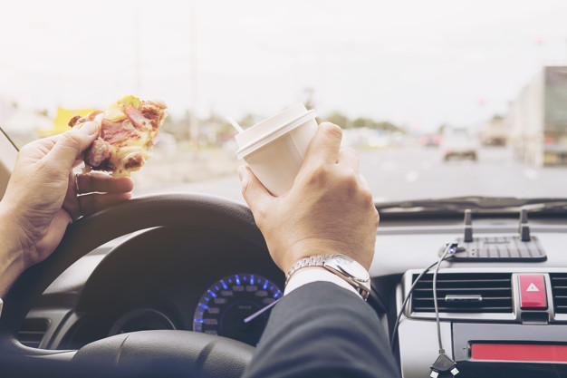 man eating pizza coffee while driving car dangerously 1150 6440