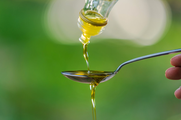 pouring olive oil into spoon green park garden background 51195 3772 1