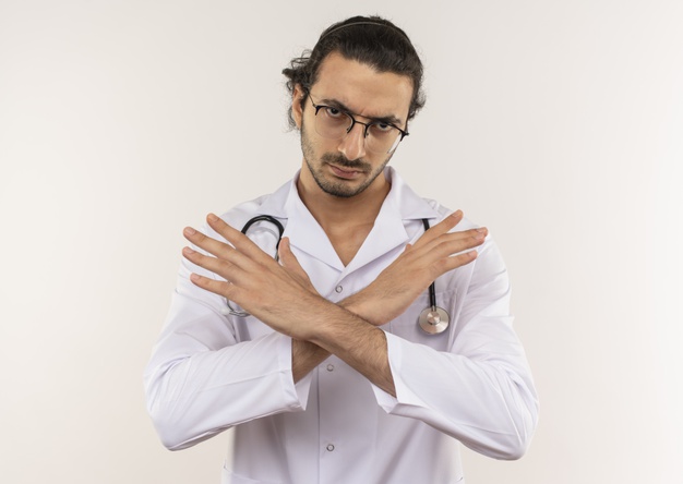 strict young male doctor with optical glasses wearing white robe with stethoscope showing gesture no isolated white wall with copy space 141793 78211